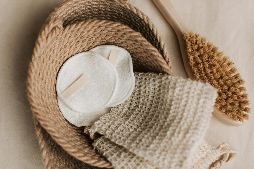 A top view of eco-friendly skincare items like cotton pads and brush in a jute basket. Sustainable lifestyle.