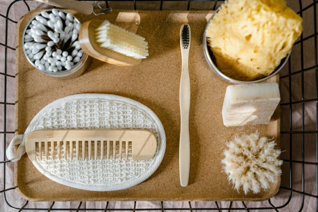 Top view of eco-friendly bath essentials including soap, sponge, and toothbrush on a tray.